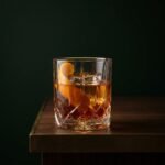 An Old Fashioned in a cut-crystal rocks glass with a wide strip of orange peel